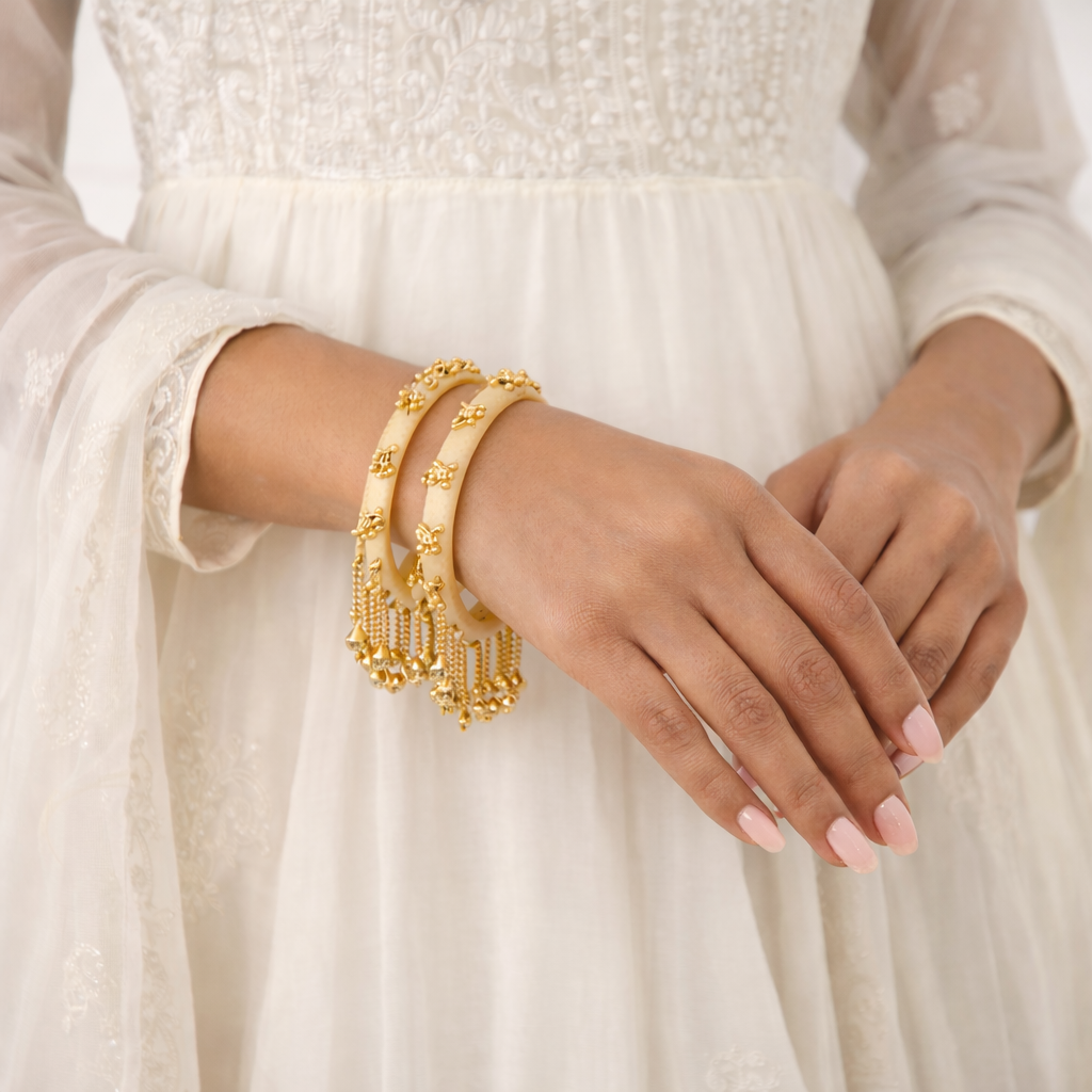 Etnico Traditional Ivory-Tone Bangles with Brass Stud Detailing and Hanging Ghungroo Charms for Women (ADB595Cr)